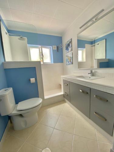 a blue bathroom with a toilet and a sink at Puerto del Carmen Las caracolas Acogedor espacioso y luminoso apartamento cerca del mar in Puerto del Carmen