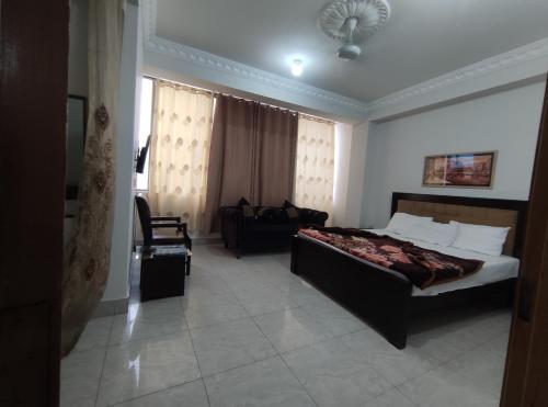 ムザファラバードにあるMarina Residencyのベッドとソファ付きのホテルルーム