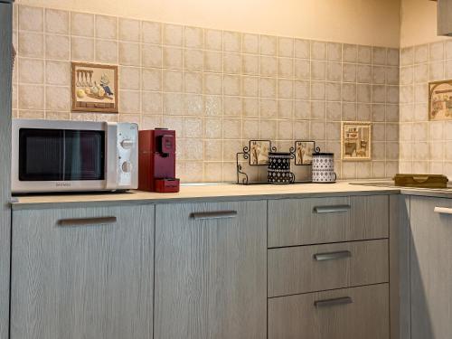 a kitchen with a microwave sitting on top of a counter at Villa Donata Fontane Bianche in Fontane Bianche