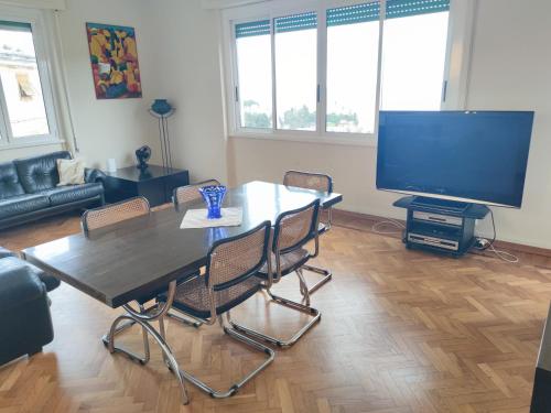 ein Wohnzimmer mit einem Tisch und einem Flachbild-TV in der Unterkunft Il girasole in Rapallo