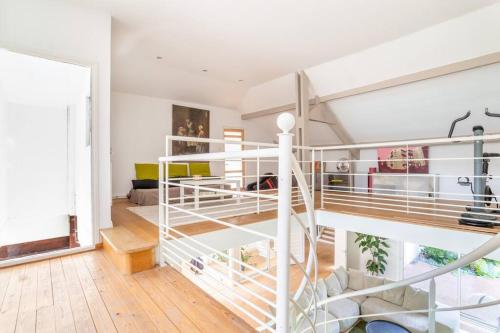 une chambre mansardée blanche avec un escalier en colimaçon dans l'établissement Luxueuse Villa avec Piscine, Sauna et Étang - à 15 minutes de Lille !, à Ennetières-en-Weppes
