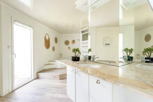 une salle de bain avec deux lavabos et un grand miroir dans l'établissement Luxueuse Villa avec Piscine, Sauna et Étang - à 15 minutes de Lille !, à Ennetières-en-Weppes