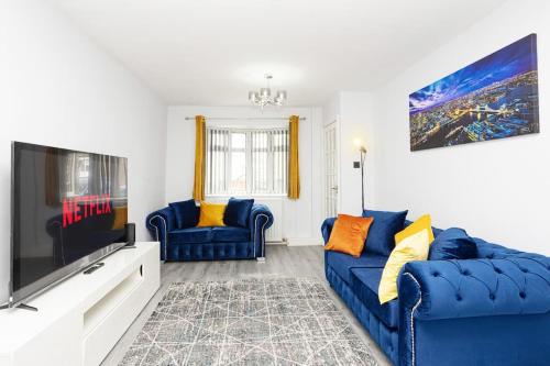 a living room with a blue couch and a flat screen tv at Urban Gem in Longbridge