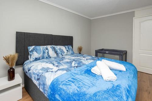 a bedroom with a blue and white bed with two pillows at Urban Gem in Longbridge