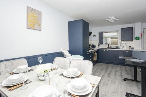 a dining room with a table and chairs and a kitchen at Urban Gem in Longbridge