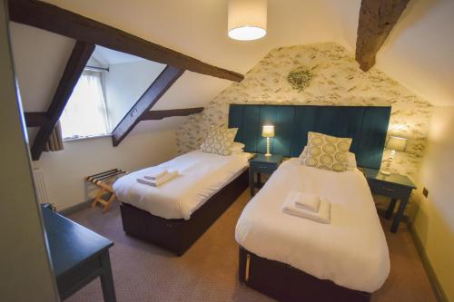 a attic room with two beds and a window at Red Lion Inn in Hawkshead