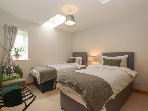 a bedroom with two beds and a window at Vallum Rest in Carlisle
