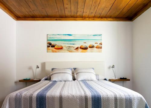 a bedroom with a bed with a painting on the wall at Puerto del Carmen Las caracolas Acogedor espacioso y luminoso apartamento cerca del mar in Puerto del Carmen