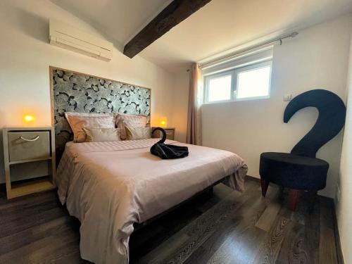 une chambre avec un lit avec un point d'interrogation sur le mur dans l'établissement Charme urbain sous les toits-Terrasse/Clim/Parking, à Béziers