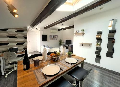 un salon avec une table et des chaises dans l'établissement Charme urbain sous les toits-Terrasse/Clim/Parking, à Béziers