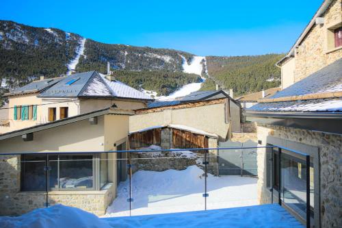 Cette maison dispose d'un balcon avec de la neige au sol. dans l'établissement Les Fermes de Cal Panche : La Ferme, aux Angles