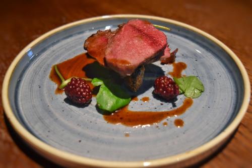 a plate of food with meat and berries on it at Red Lion Inn in Hawkshead