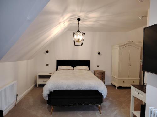 Un dormitorio con una cama grande y una lámpara de araña. en Linroy Guest House en Skegness