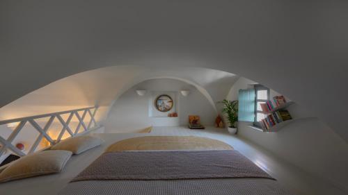 an attic bedroom with a bed and a staircase at Michelangelo Beach Villa in Oia