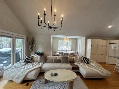 a living room with a couch and a chandelier at Modern House Family Retreat in Bar Harbor