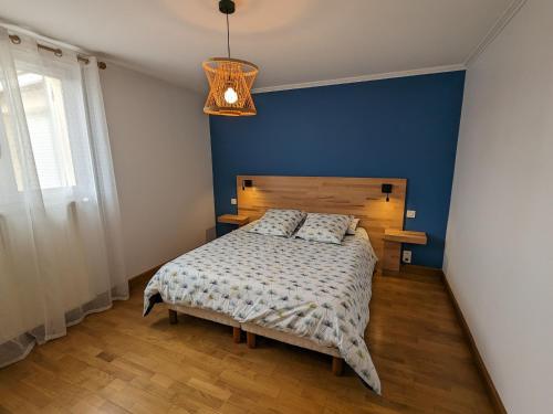 a bedroom with a bed with a blue wall at Gîte de charme avec jardin et parking privé près de Paris et Orléans - FR-1-590-428 in Oison