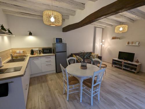une cuisine et une salle à manger avec une table et des chaises dans l'établissement Gîte de charme avec jardin et parking privé près de Paris et Orléans - FR-1-590-428, à Oison