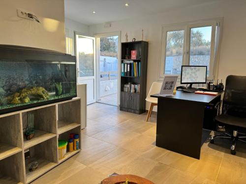 un bureau avec un aquarium et un bureau dans l'établissement Villa Agas, à Karterados