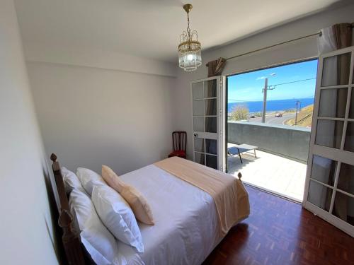 a bedroom with a bed and a sliding glass door at Casa a Torre in Santa Cruz