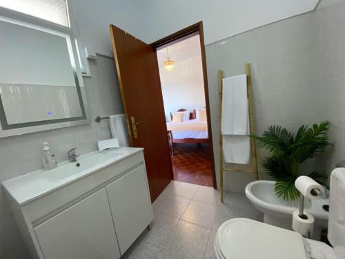 a bathroom with a sink and a toilet and a bedroom at Casa a Torre in Santa Cruz