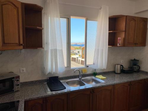 um balcão de cozinha com um lavatório e uma janela em Casa a Torre em Santa Cruz - Madeira