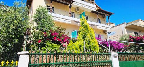 a fence in front of a house with flowers at Apartments Athina Orikum in Orikum
