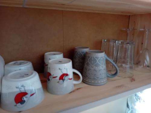 a shelf with four coffee mugs on it at Experience accommadation Eco-Unela in Rovaniemi