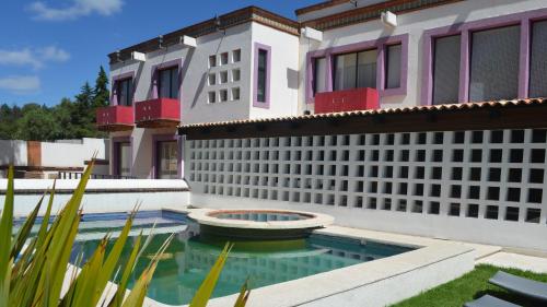 a house with a swimming pool in front of a building at HOTEL BOUTIQUE CASA DEL BOSQUE in Tlaxcala de Xicohténcatl