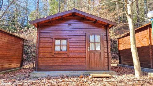 a wooden cabin with a door in the woods at Ermida Gerês Camping in Ermida
