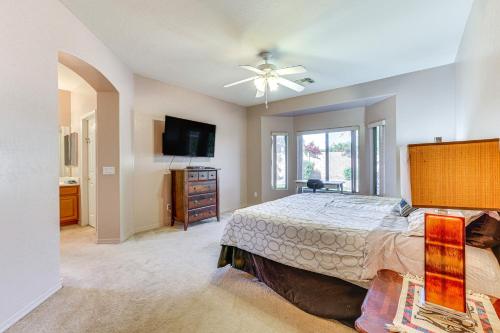 a bedroom with a bed and a flat screen tv at Goodyear Getaway with Private Pool and Outdoor Lounge! in Goodyear