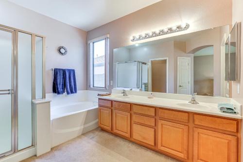 a bathroom with a tub and a sink and a mirror at Goodyear Getaway with Private Pool and Outdoor Lounge! in Goodyear