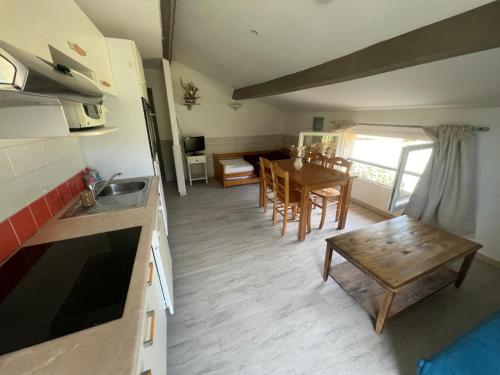 a kitchen and living room with a table and a dining room at appartement 2 bord de mer in Farinole