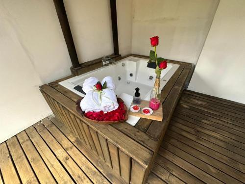a bathroom with a bath tub with towels and roses at Hermoso chalet en cabeceras de llanogrande in Rionegro