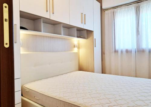 a small bedroom with a bed and a window at Aida Guest House - Decimomannu in Decimomannu