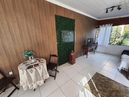 Zimmer mit einem Tisch und einer Tafel an der Wand in der Unterkunft Pousada Ventos de Outono in São Roque