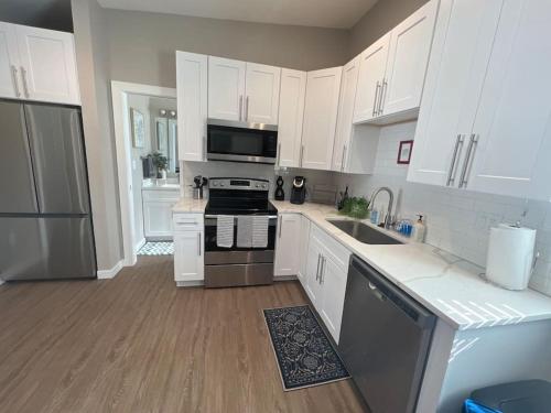 Una cocina con gabinetes blancos y un horno de estufa. en Elegant & cozy 2 bed, en Brighton