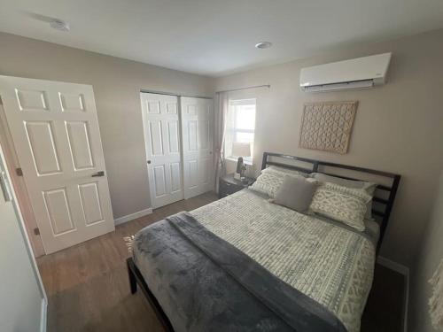 1 dormitorio con cama y puerta blanca en Elegant & cozy 2 bed, en Brighton