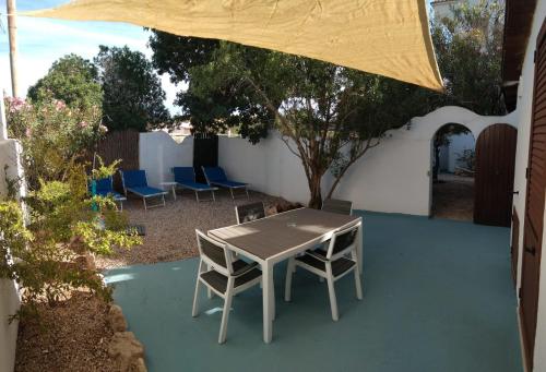 a table and chairs under an umbrella on a patio at Villa Dacla in Lampedusa