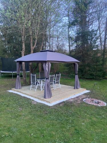 a gazebo with a table and chairs on a wooden deck at Hyllstofta lägenhet in Klippan