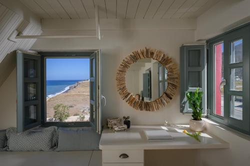 a bathroom with a mirror and a sink and a window at Michelangelo Beach Villa in Oia