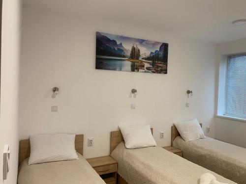 a room with two beds and a painting on the wall at Hostel Flora Mezdra in Mezdra
