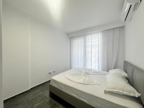 - une chambre blanche avec un lit et une fenêtre dans l'établissement Appartamento Andrea vista mare Shëngjin, à Shëngjin
