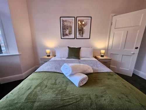 a bedroom with a large bed with two lamps at Brunswick Park Shared House in Wednesbury