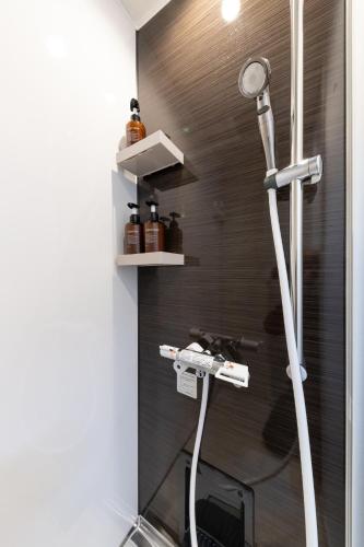 a shower with a shower head in a bathroom at CITY HOTEL UMEDA Residence in Osaka