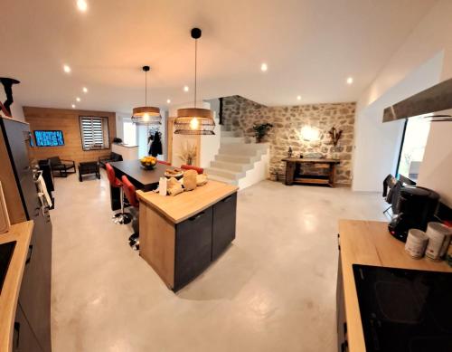 Il comprend un grand salon avec une cuisine et une salle à manger. dans l'établissement Maison centre de Saugues avec terrasse et terrain, à Saugues