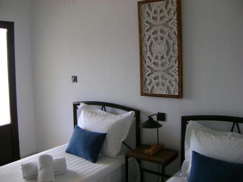 um quarto com duas camas e uma foto na parede em Pansion Thanos em Ouranoupoli