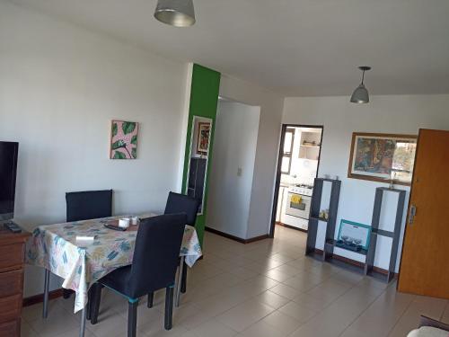 a dining room with a table and chairs and a kitchen at Departamento Plaza Moreno con balcón in La Plata