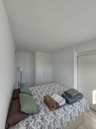 Un dormitorio con una cama con almohadas. en Cómodo apartamento en Madrid, en Madrid