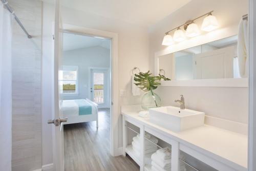 uma casa de banho branca com um lavatório e um espelho em Isla Key Guava - Waterfront Boutique Resort, Island Paradise, Prime Location em Islamorada