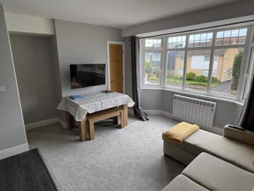 uma sala de estar com uma mesa e um sofá em New one bed 1st floor flat close to the beach em Southbourne